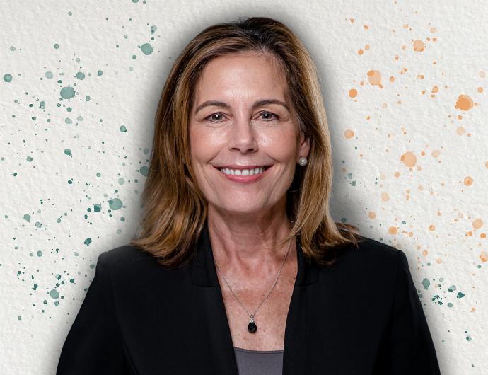 Headshot of AG Kathy Jennings in a black suit, overtop an off-white background with green and orange spatter