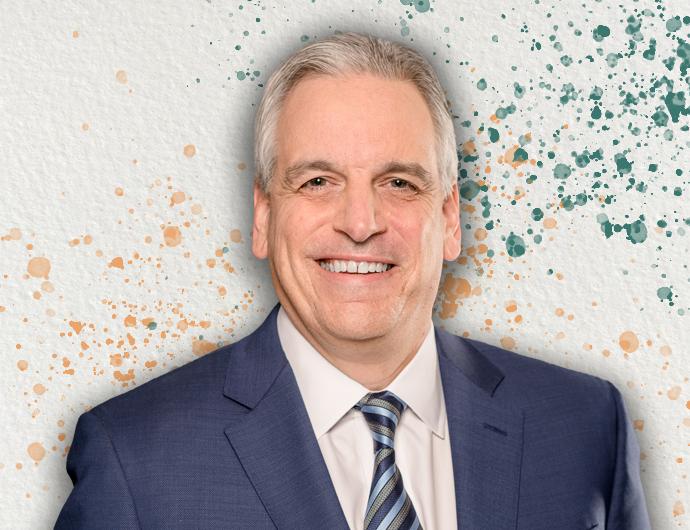 Headshot of AG Peter Neronha in a blue suit with blue and grey striped tie, overtop an off-white background with orange and green spatter